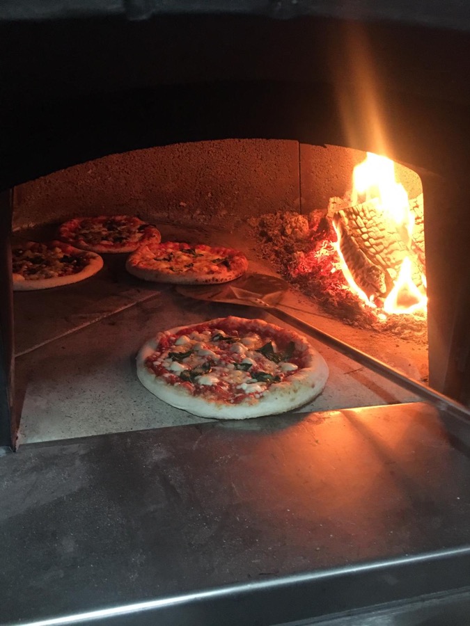 Pizzas cooking in the wood fired oven