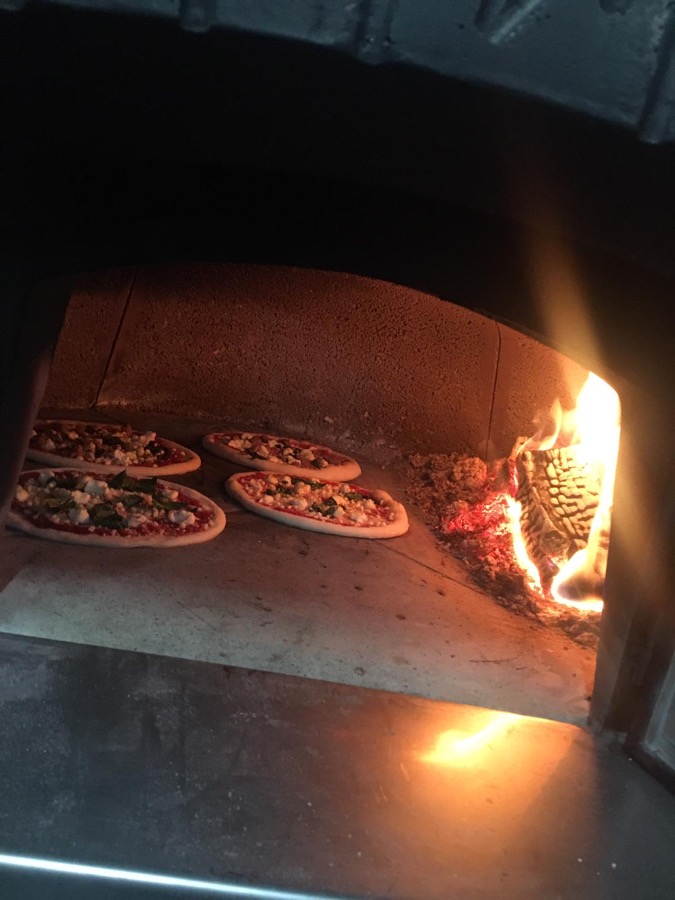 Four pizzas cooking together